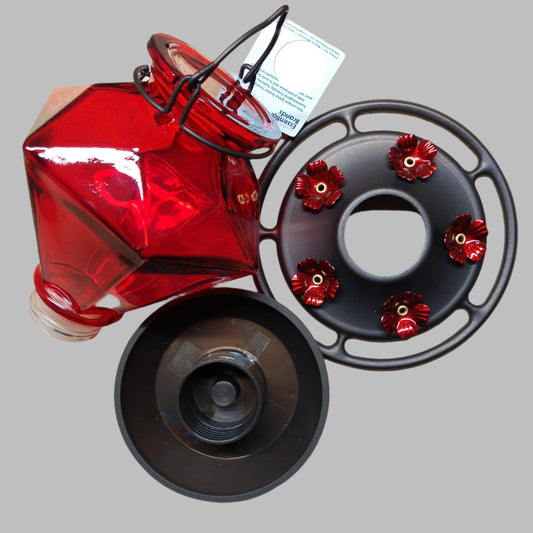 Red diamond shaped glass bottle with two dark base pieces with red flowers