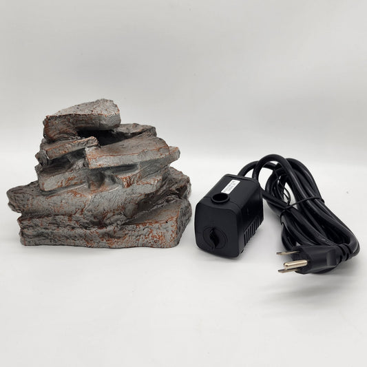 Gray stacked faux rocks and black pump with cord