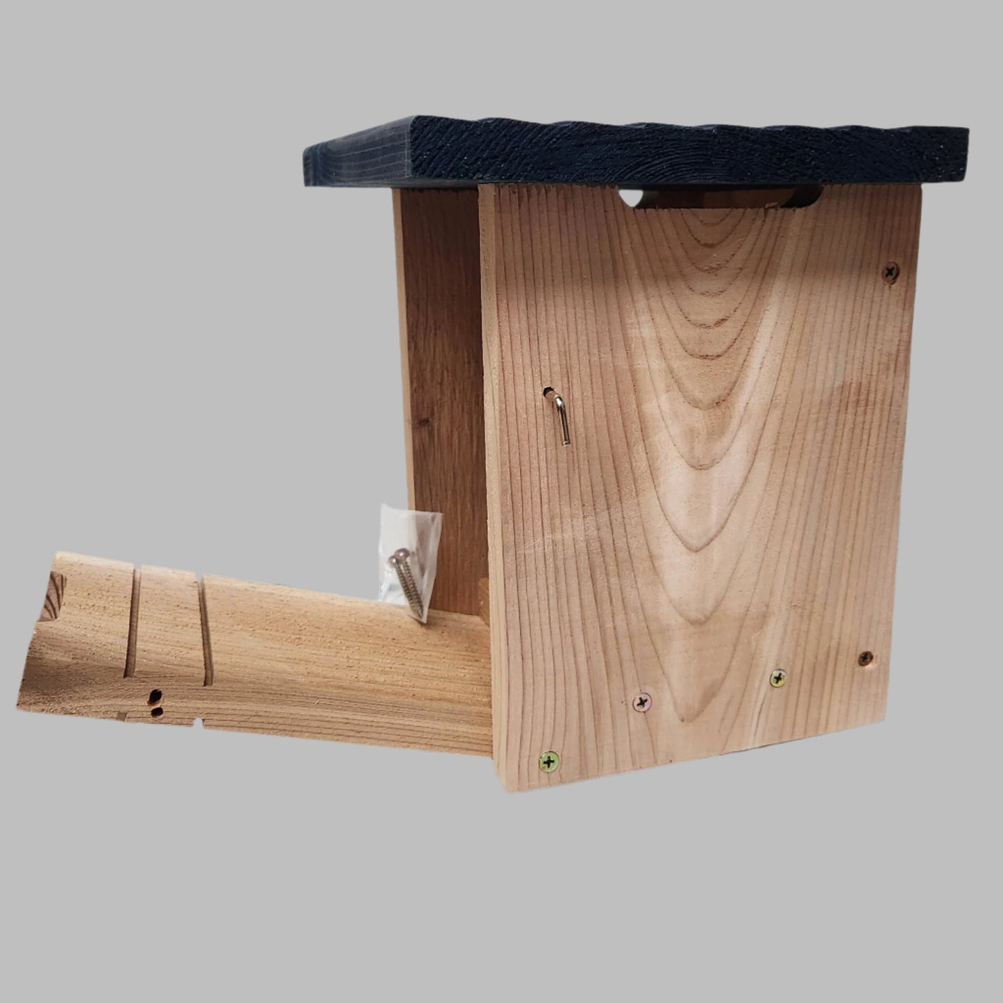 cedar bird house with blue roof and door open