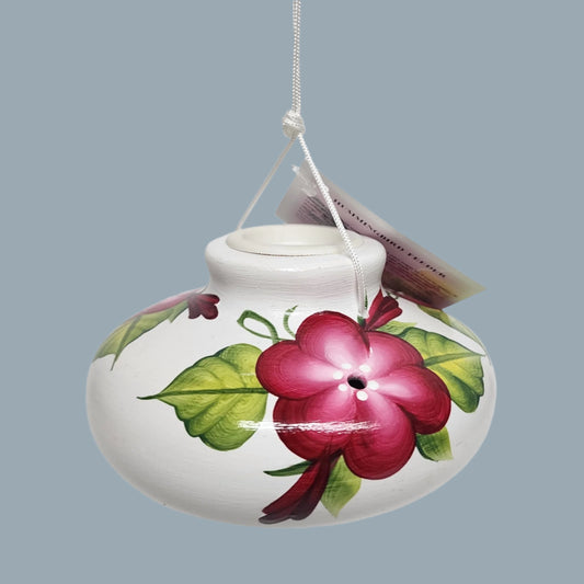 garnet posy flowers on a white ceramic hummingbird feeder
