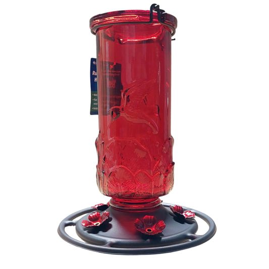 Red glass bottle hummingbird feeder with dark base and red flowers
