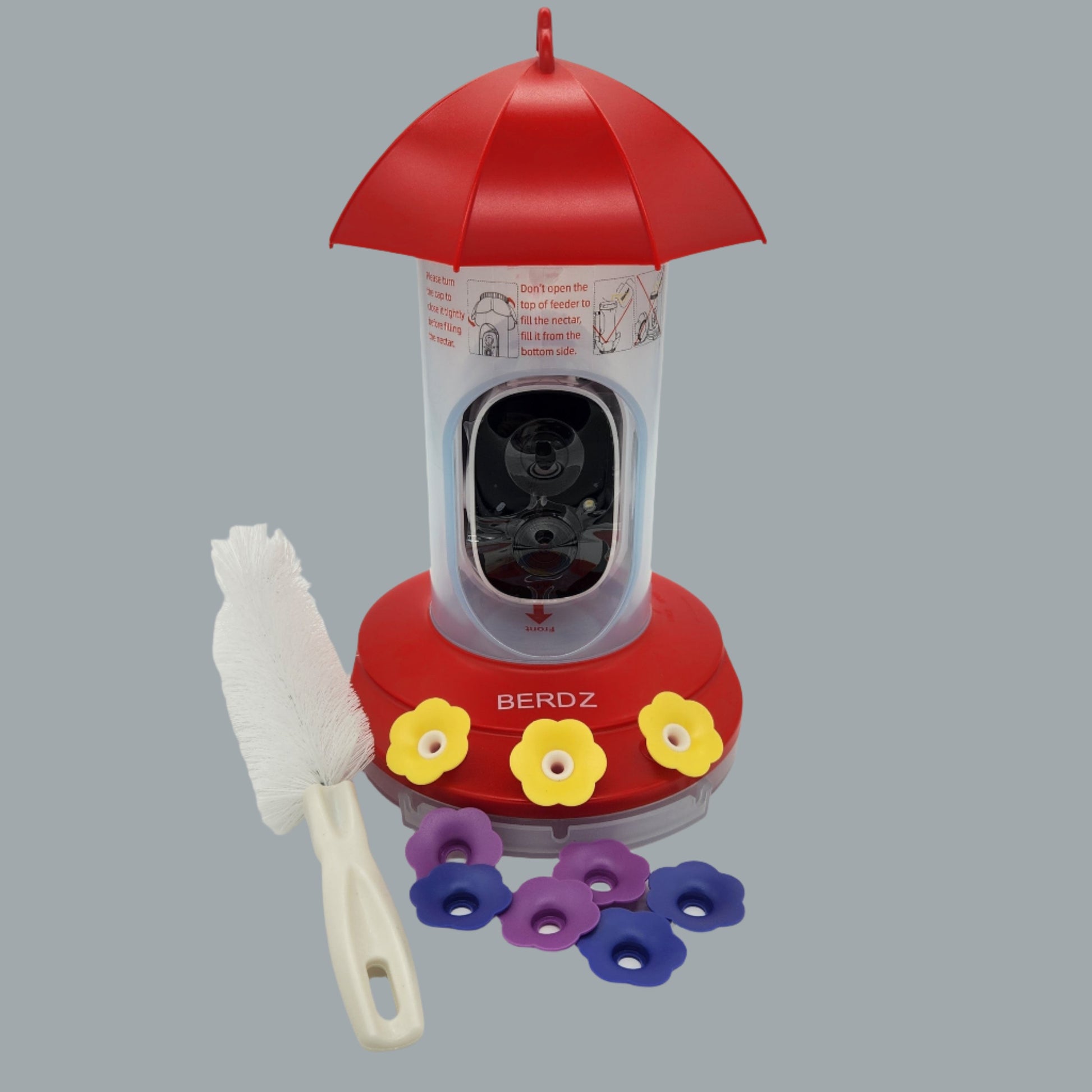 clear feeder with camera and red top and base with yellow flowers, brush and replacement flowers