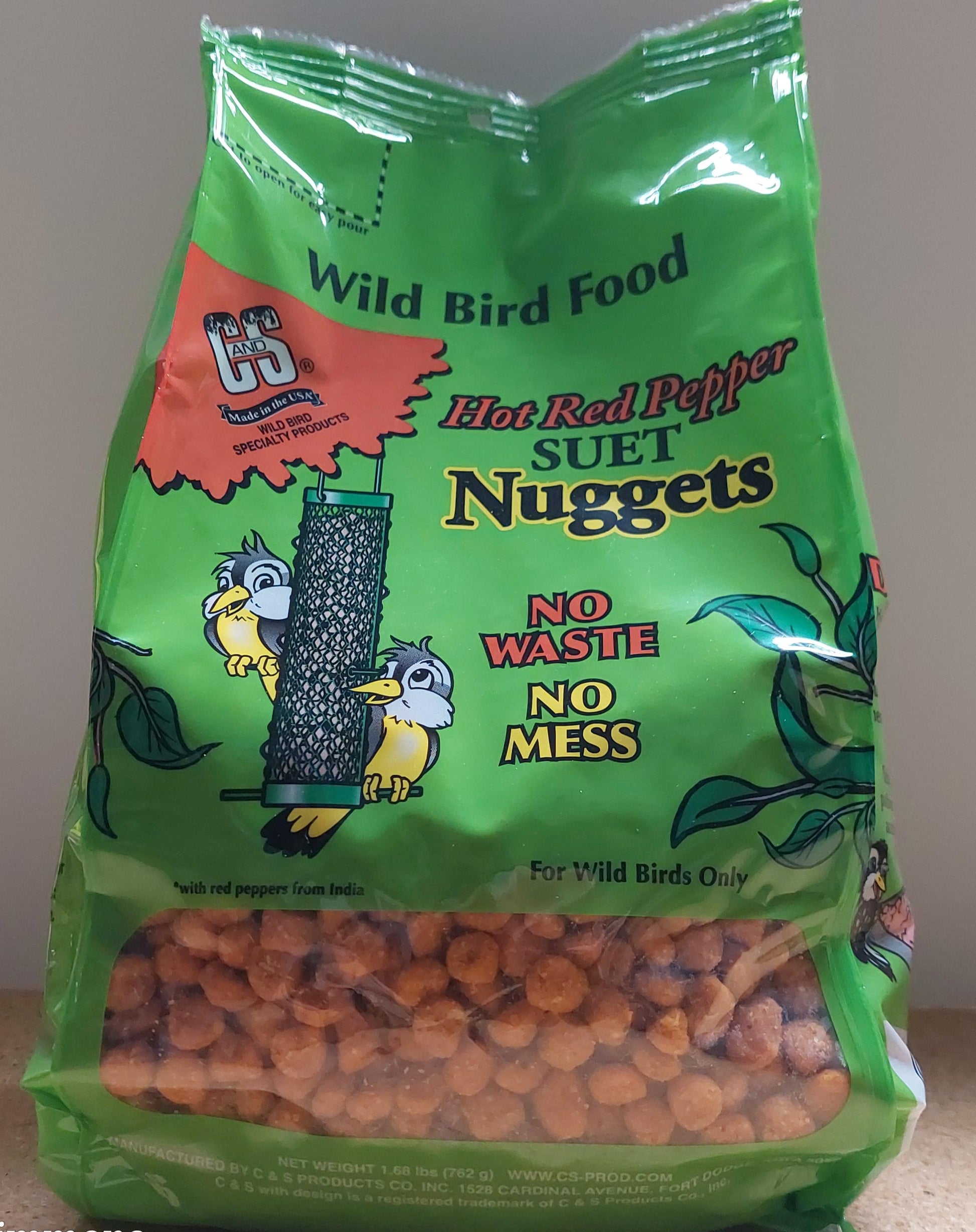 Green bag of Wild Bird Food with orange bird seeds on a neutral background