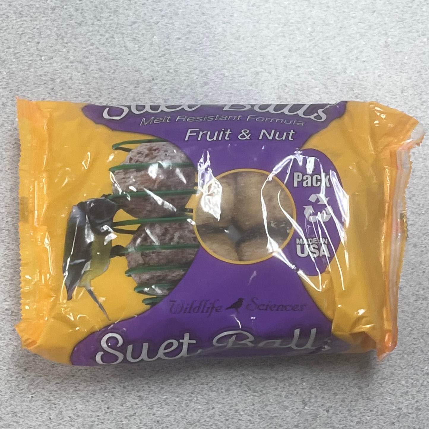 Packaged suet balls with a purple label on a gray background