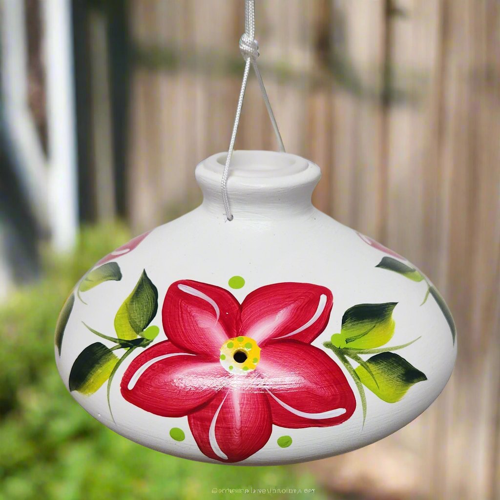 White ceramic feeder with red flowers and green leaves