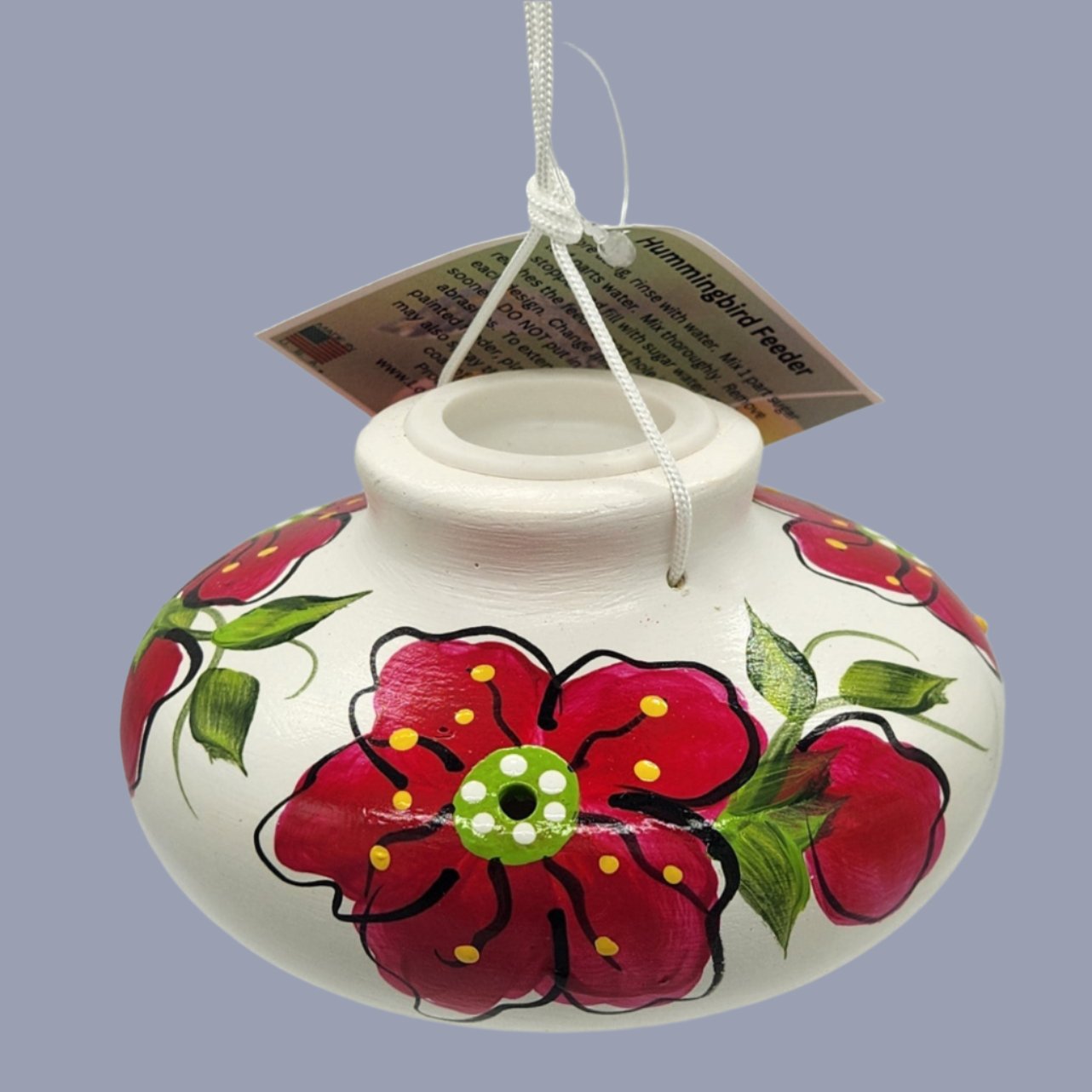 White cramic feeder with red flowers