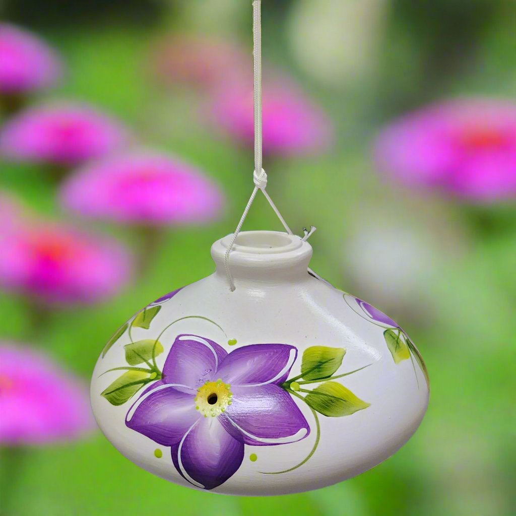 White ceramic feeder with purple flowers and green leaves