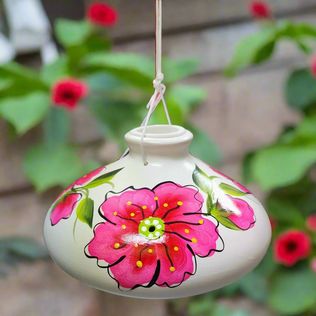 white ceramic feeder with pink flower and green leaves