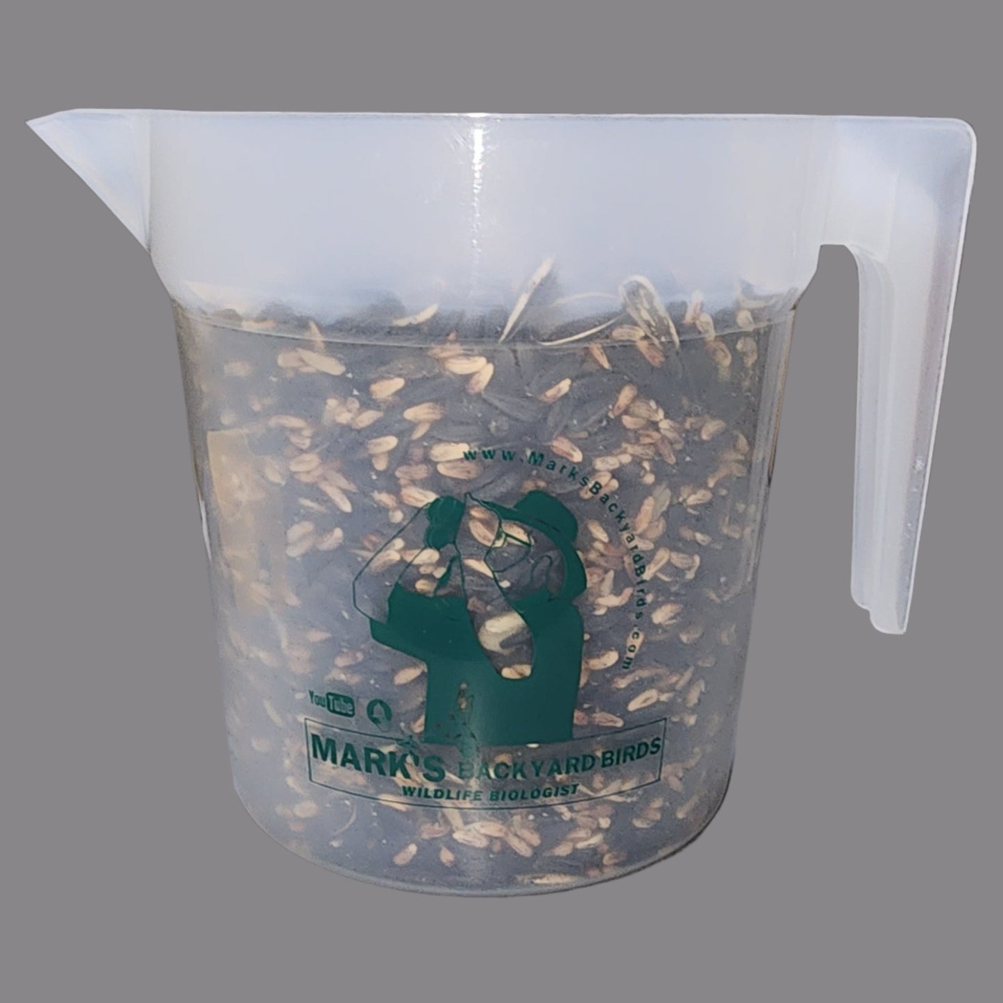 Clear pitcher with bird seed and green label