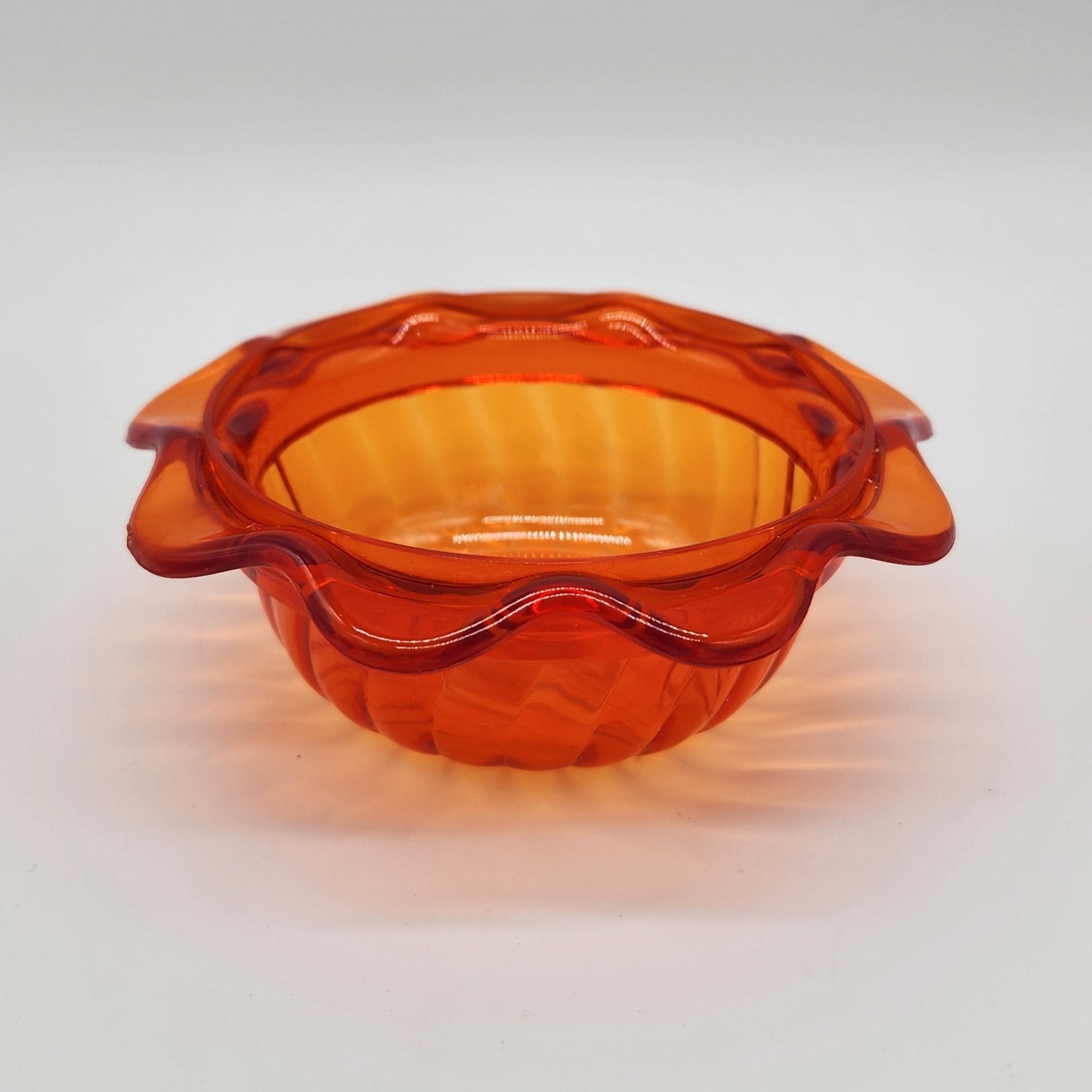 Orange plastic cup with scalloped edges