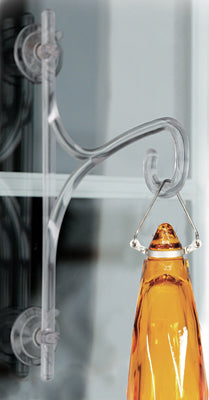 Clear acrylic window hook with a hanging amber-colored bottle against a blurred background