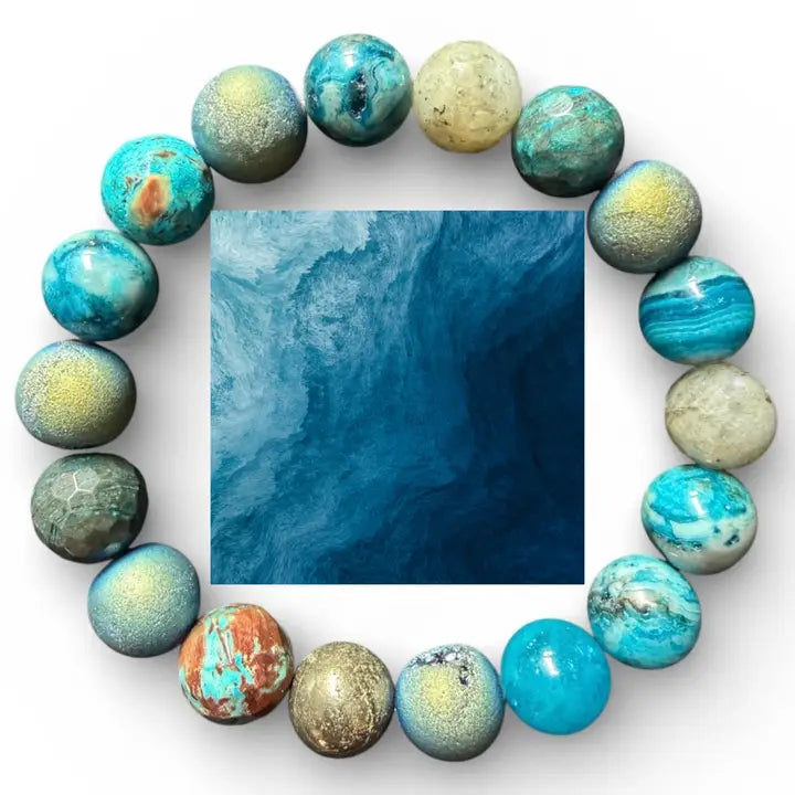 A circular arrangement of polished gemstone beads in turquoise, blue, green, gold, and rust tones, surrounding a square abstract blue artwork on a white background.