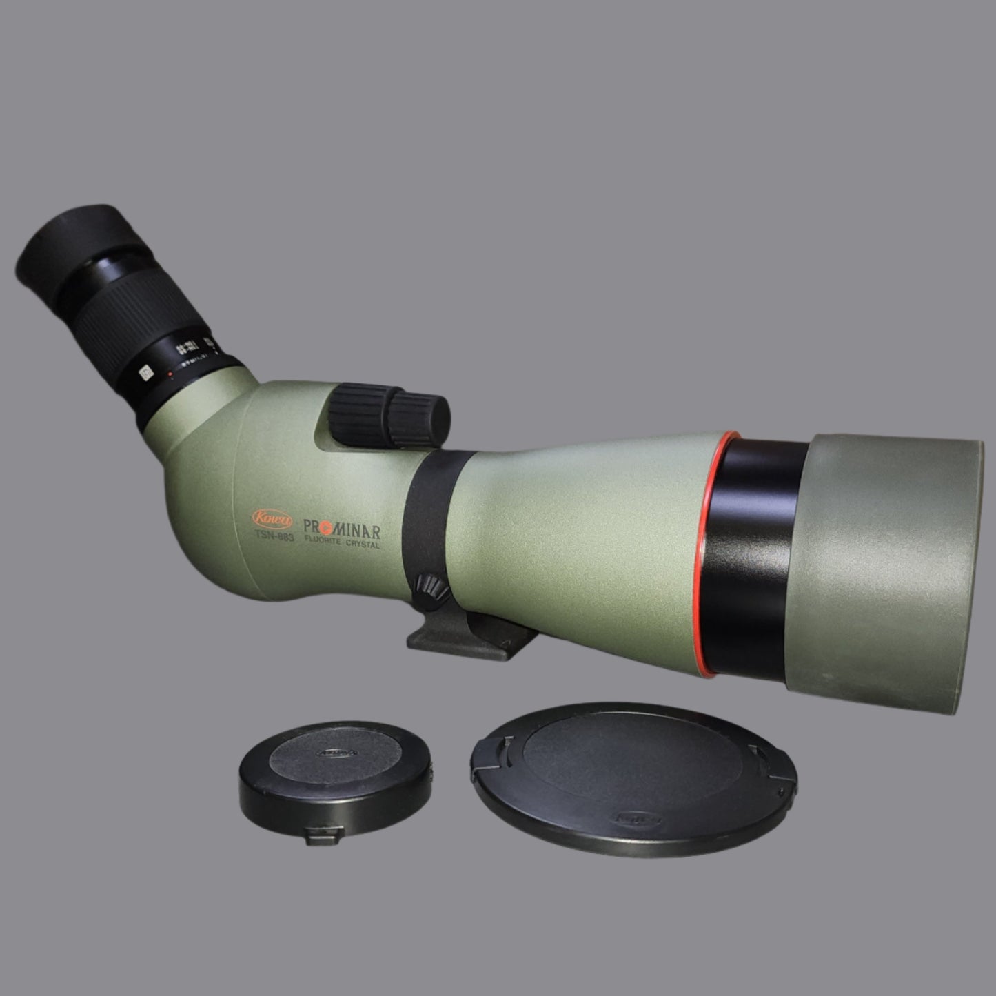 Green and black spotting scope with black lens covers