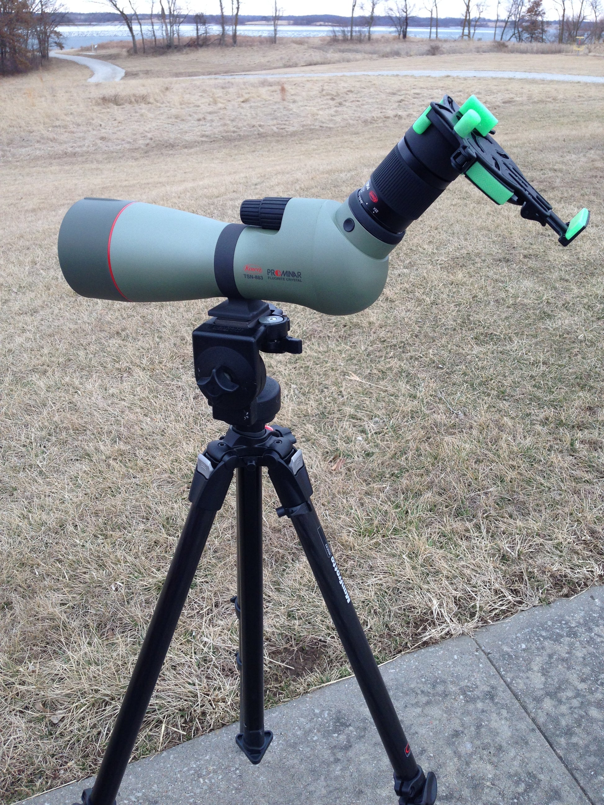 Green spotting scope with Digiscoping adapter and phone attached