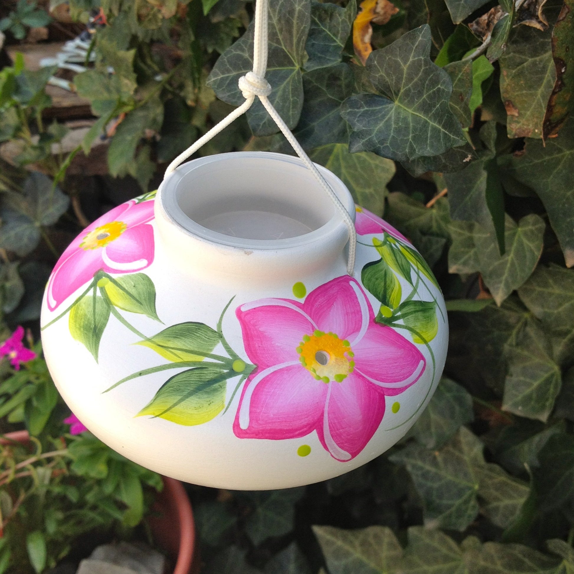 White ceramic hummingbird feeder with hand-painted pink kona flowers